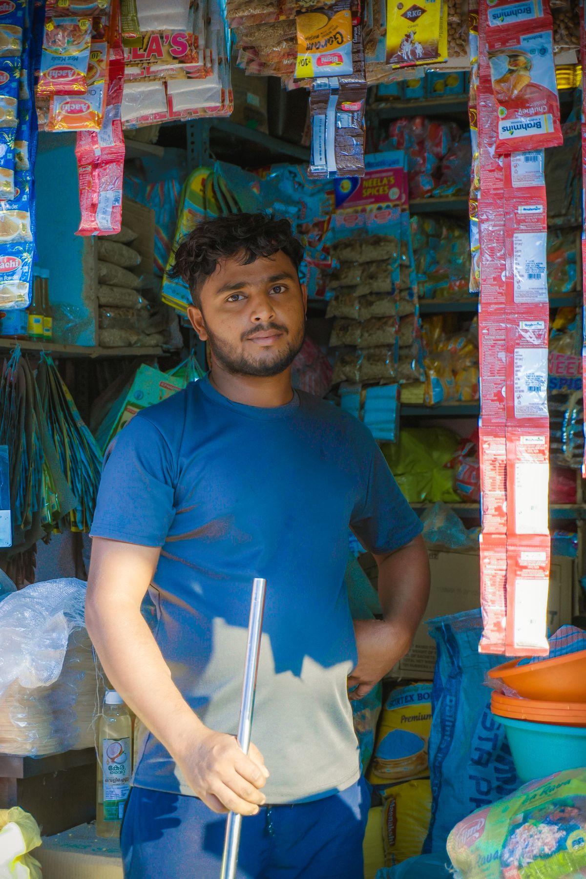 Shopkeeper standing at the entrance of a local grocery store