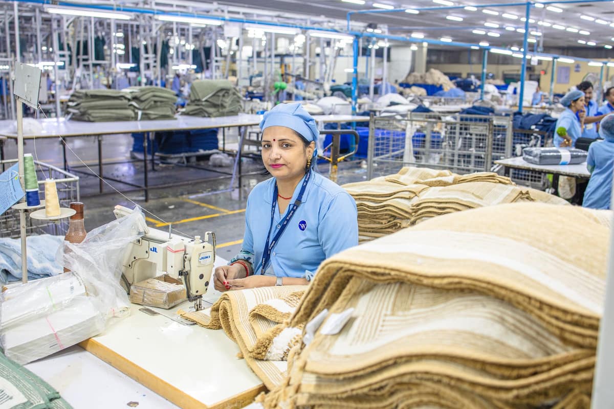 Worker at a stock table in a busy Indian textile factory