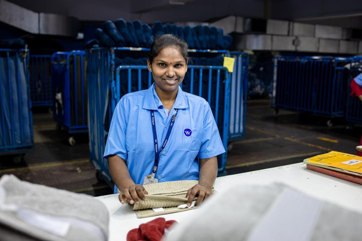 Smiling worker packing orders in an Indian textile warehouse