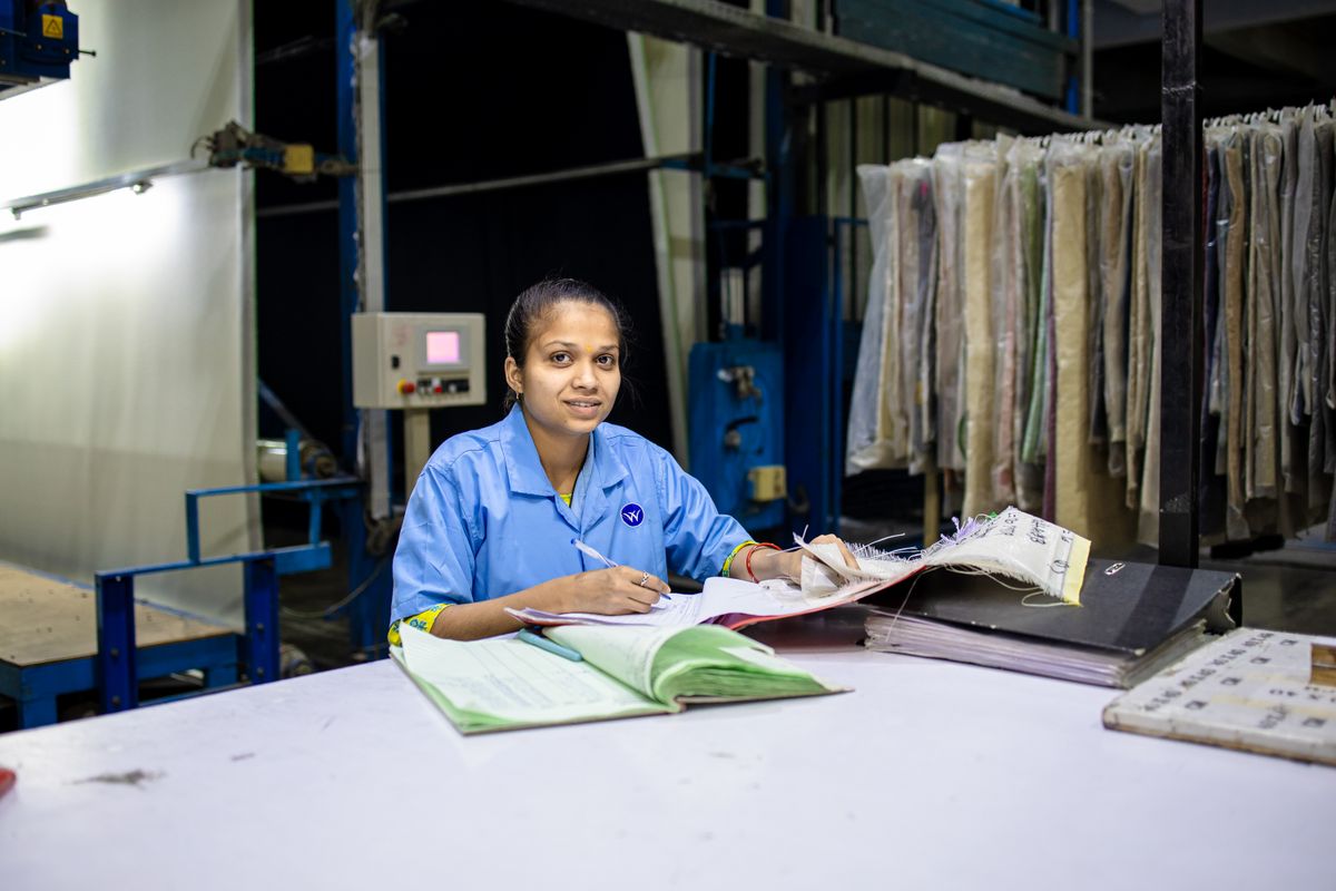 Factory employee filling in a paper attendance register
