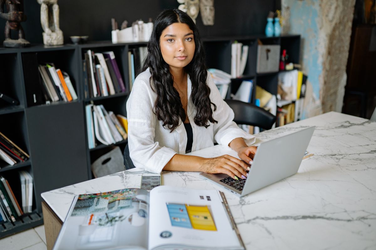 Woman using a laptop at a desk while evaluating HR software for an Indian business