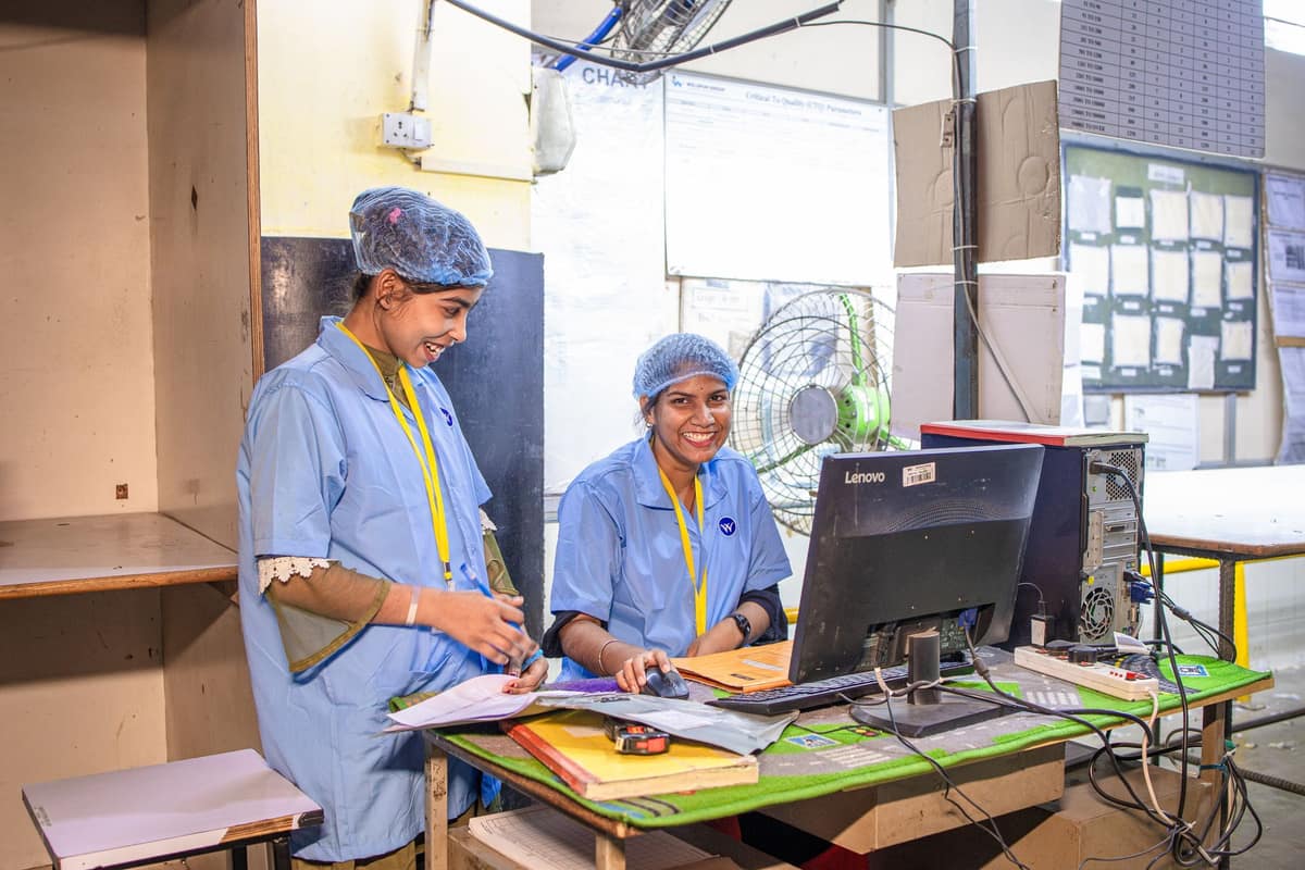 Smiling women workers at a textile factory workstation in India