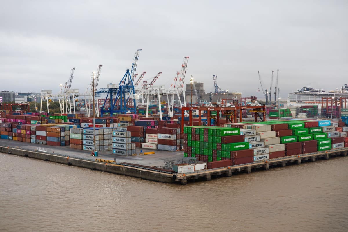 Large container port with cranes and stacked shipping containers