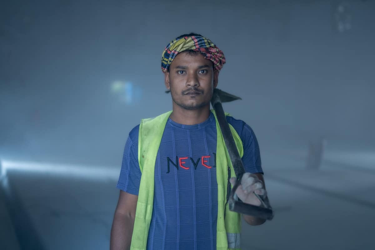 Indian site worker in a safety vest at an industrial workplace