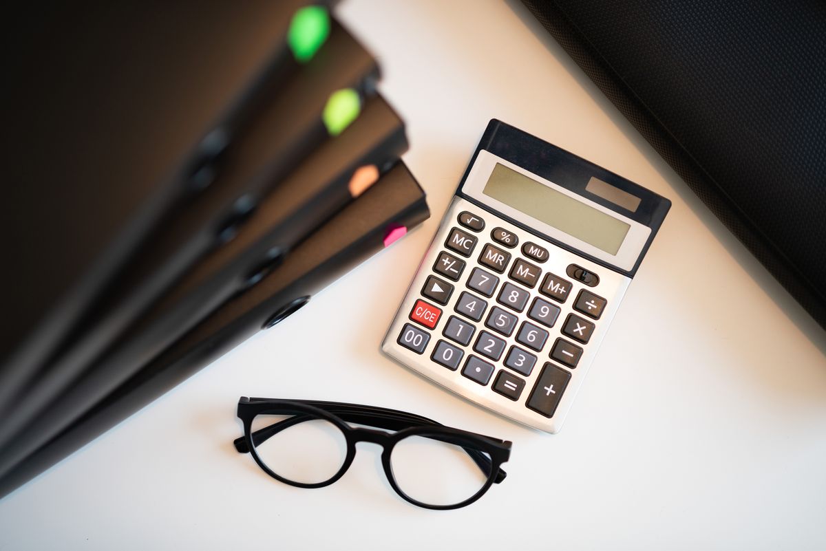 Calculator, glasses and folders on a desk for tax filing