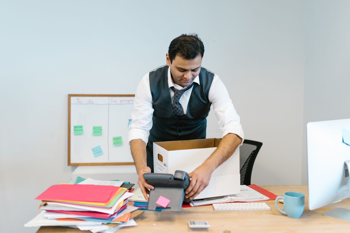 Employee packing his belongings into a box at his desk