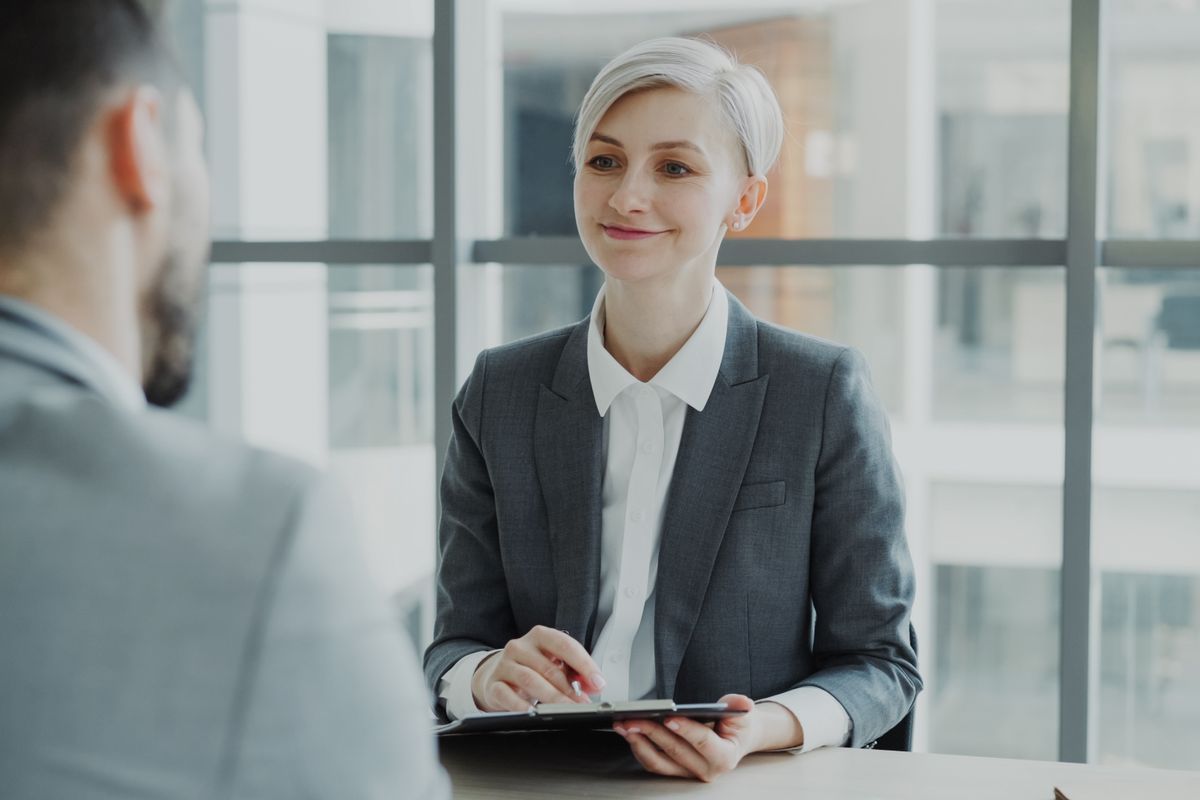 Confident woman interviewing a candidate in a modern office.