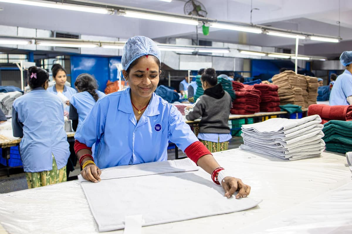 Indian textile workers sorting returned fabric on a factory floor