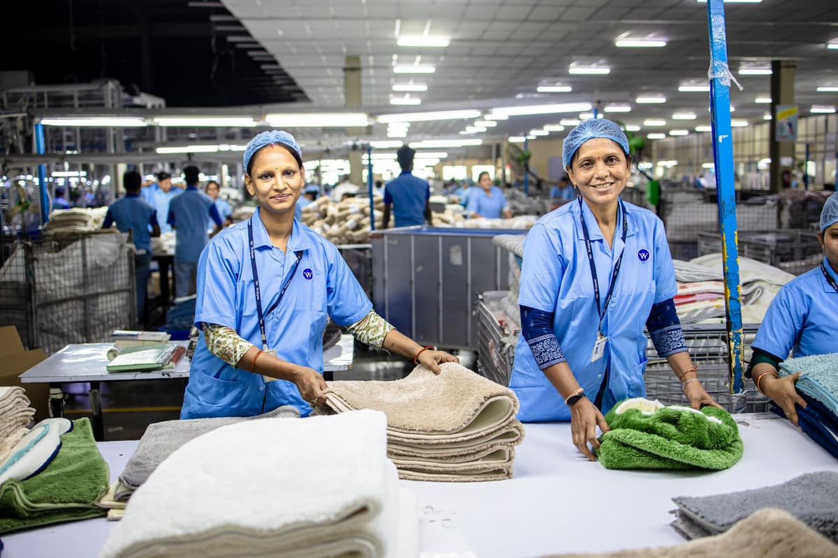 Smiling women workers sorting towels in an Indian factory