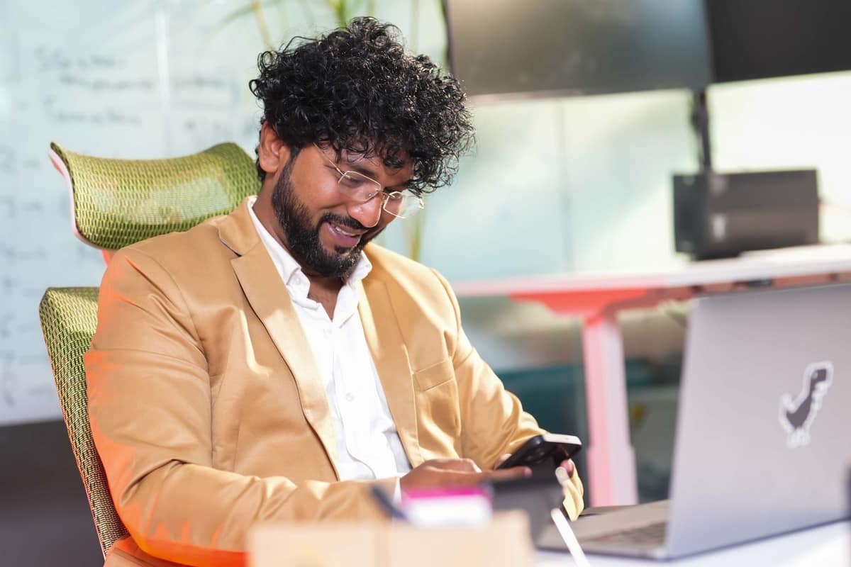 Indian businessman checking a one-time password on his phone at his office desk