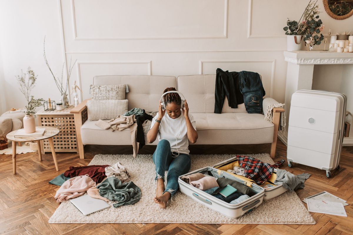 A woman packs a suitcase in her living room, getting ready for time off.