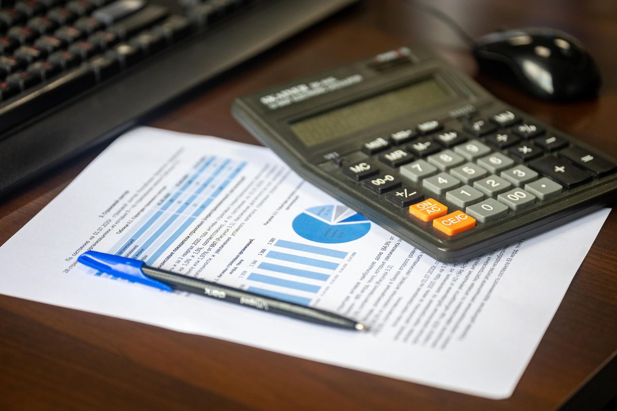 Calculator and financial report on a desk for calculating return on investment