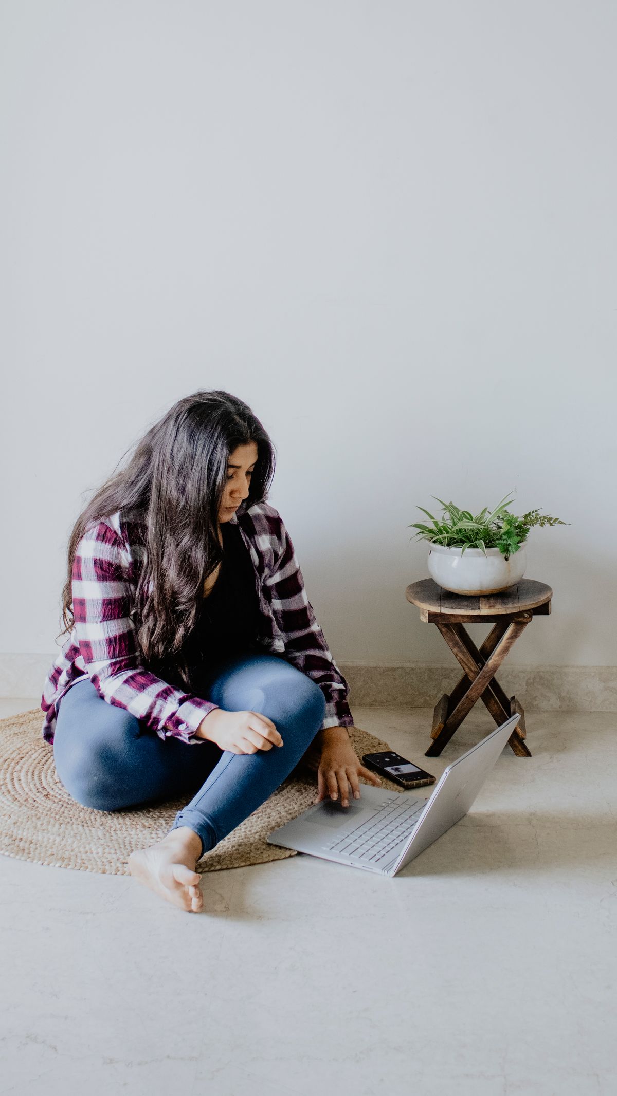 Young woman reading on a laptop while researching payroll compliance questions