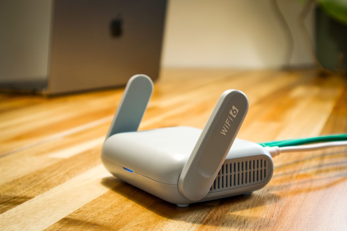 Wi-Fi router on a wooden desk, representing an internet allowance for employees