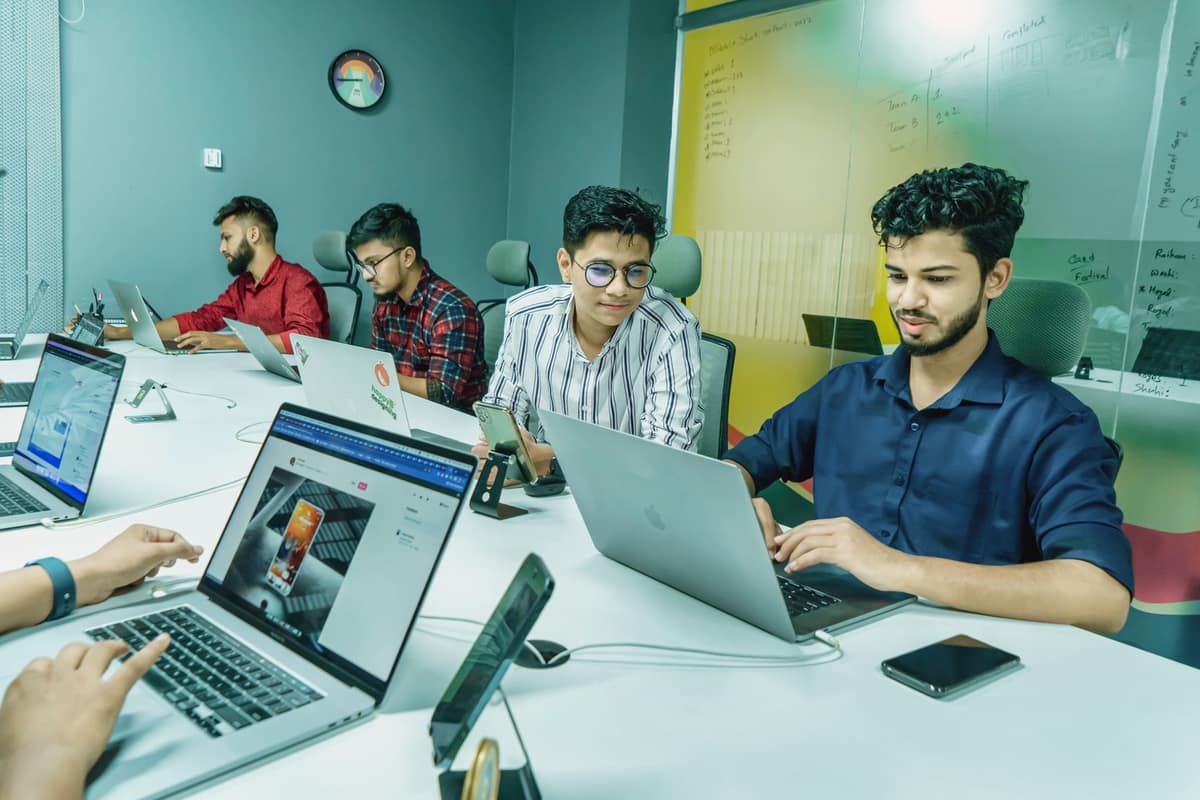 Indian team working on laptops in a shared office