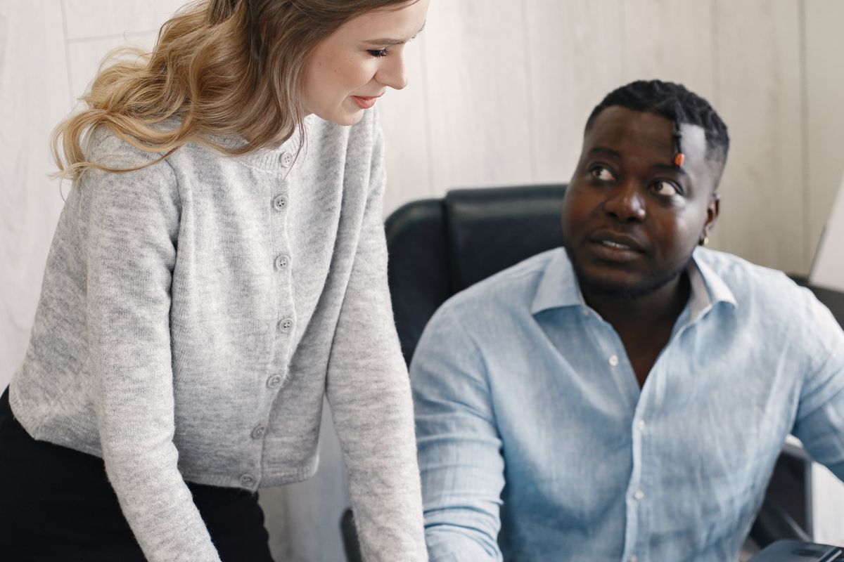 Two professionals discussing work in an office environment.