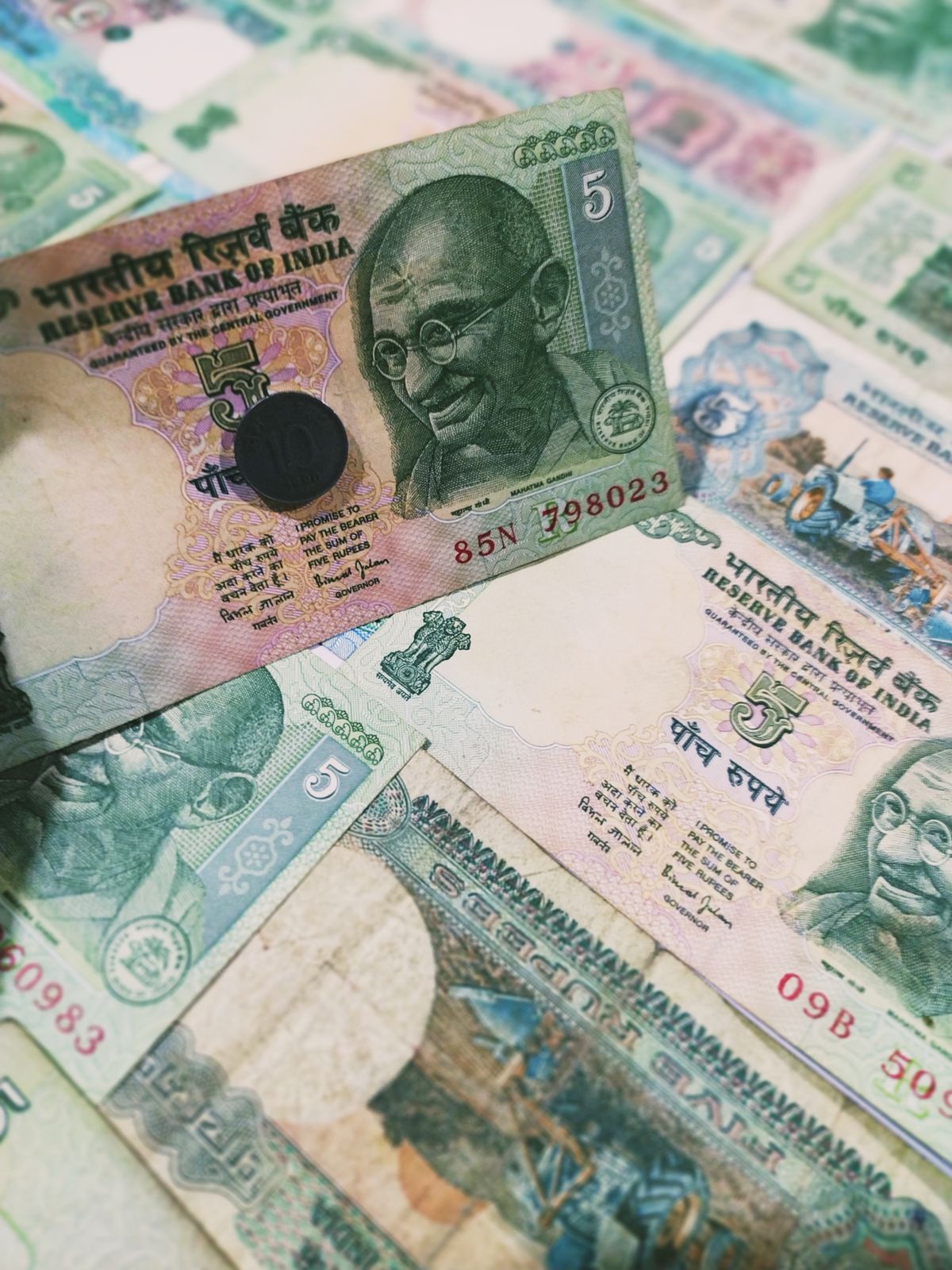Close-up of old Indian rupee notes and a coin