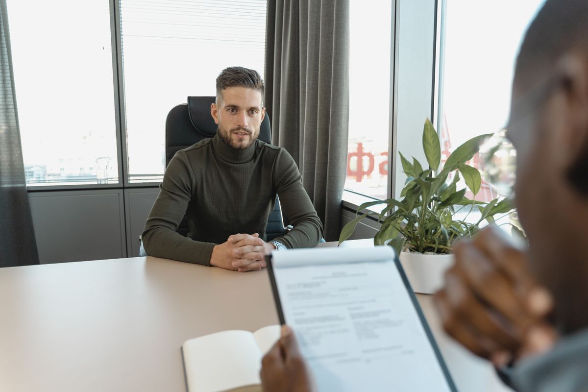 Manager interviewing a new hire at an office desk