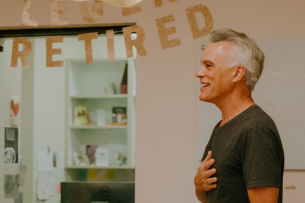 A happy retiree celebrates his retirement with a heartfelt smile indoors.