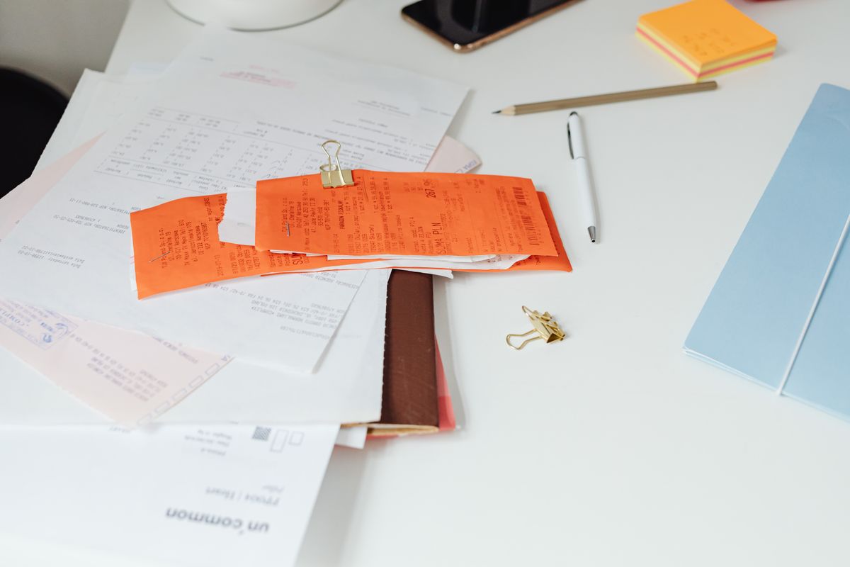 Salary slips and receipts clipped together on a desk