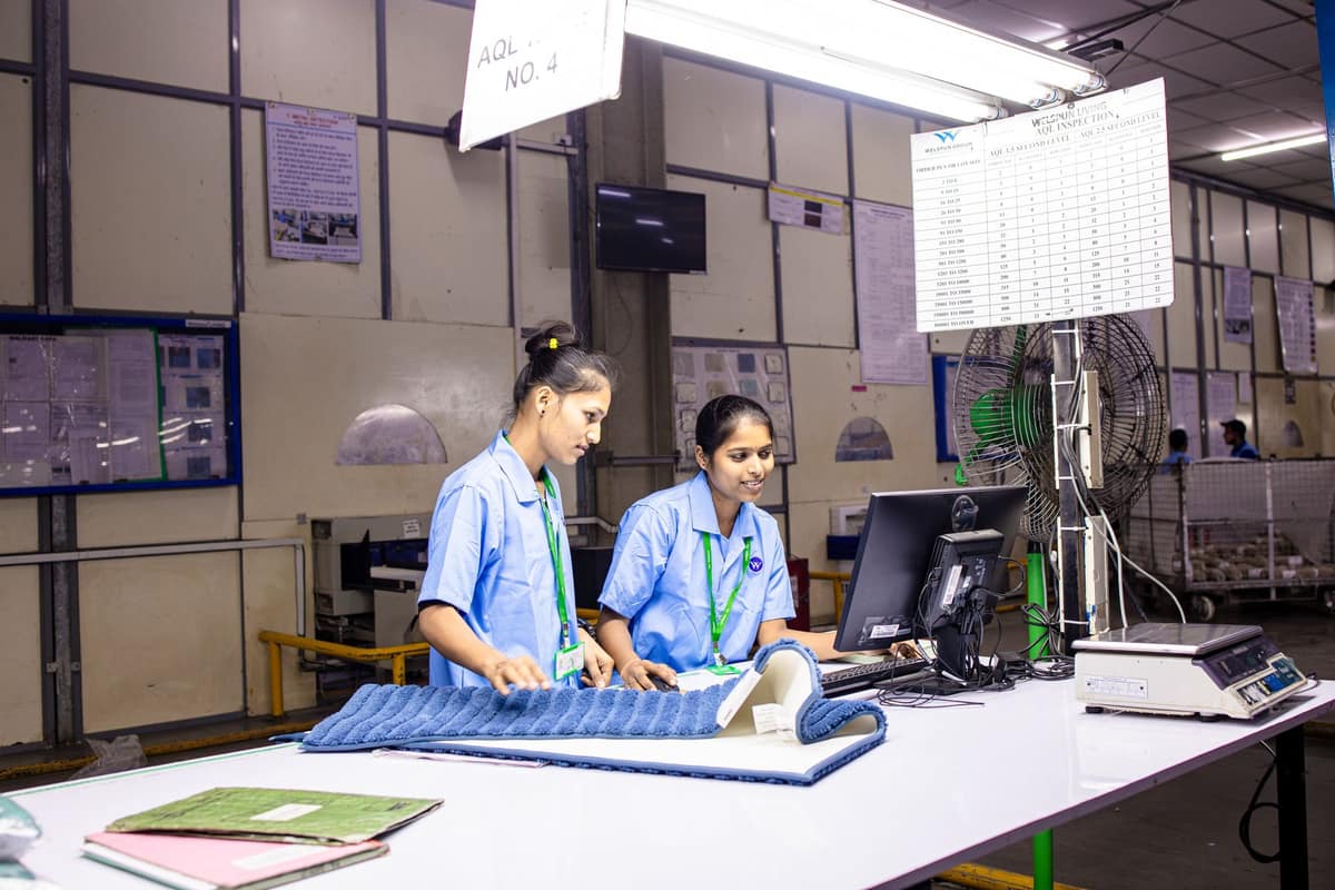 Two women at an inspection station in an Indian textile factory office