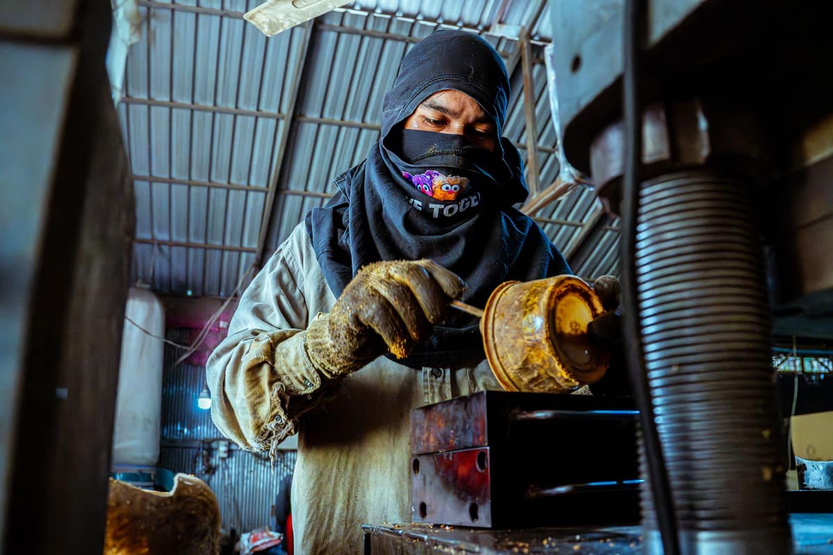 Worker in protective gear operating machinery in an Indian manufacturing unit