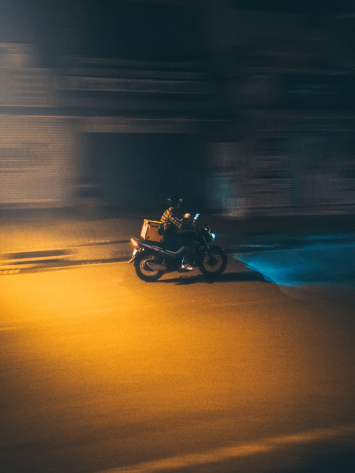 Delivery rider on a motorcycle at night, representing gig-economy work in India