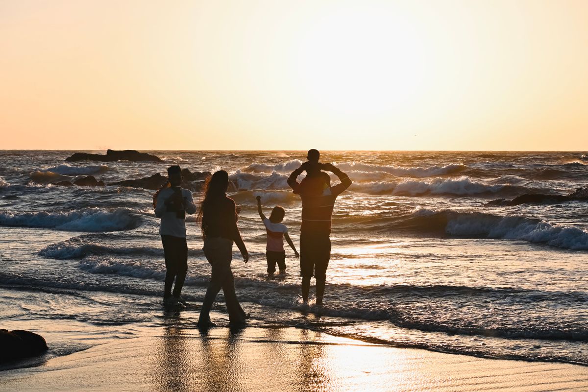 Family silhouettes on a beach at sunset, representing types of employee leave