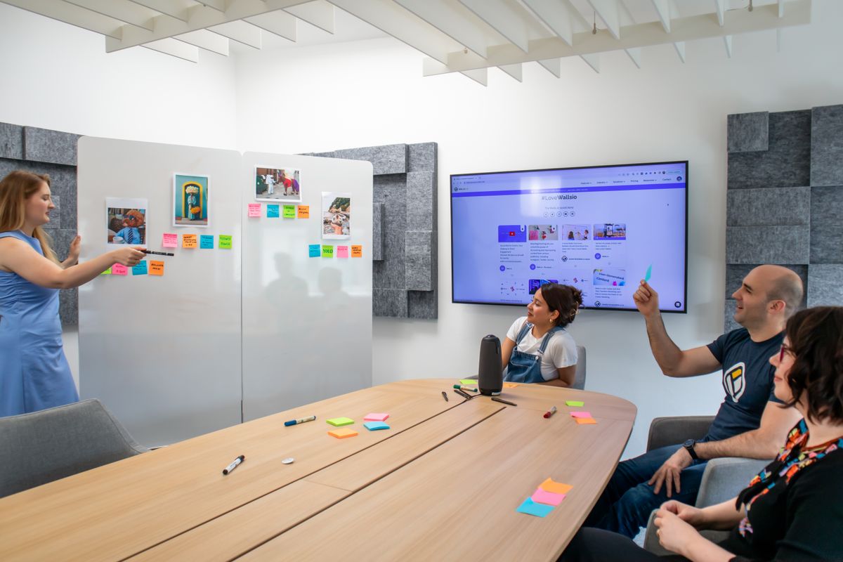 Team reviewing ratings with sticky notes on a whiteboard in a meeting room