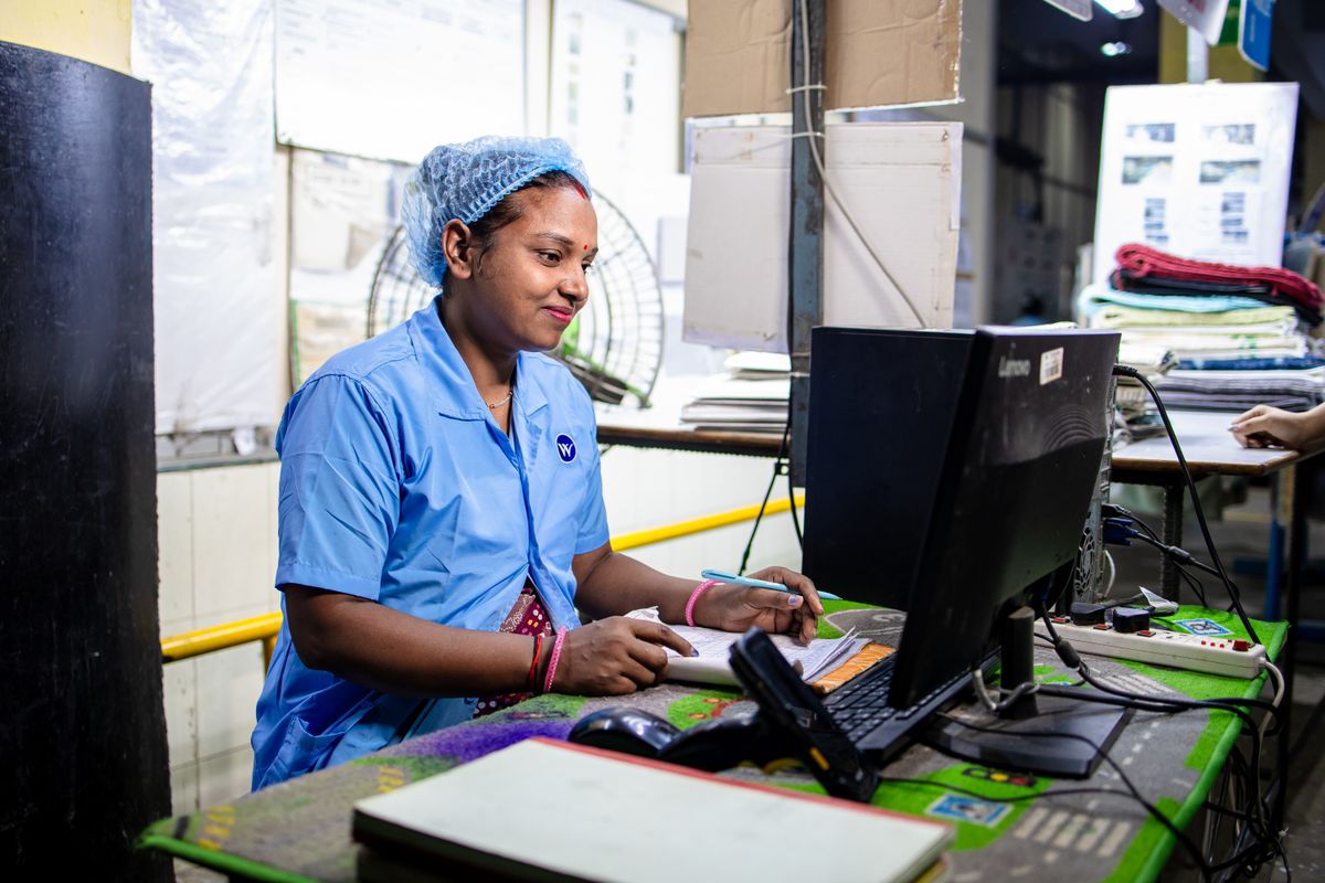 Factory employee recording attendance at a computer workstation