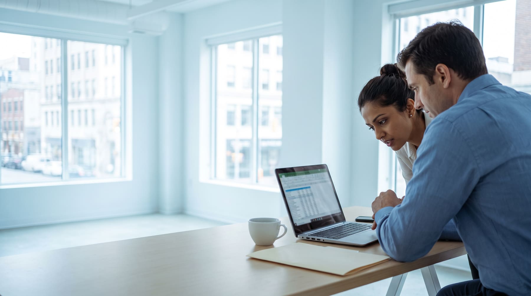 An HR manager reviewing salary sheets with a colleague